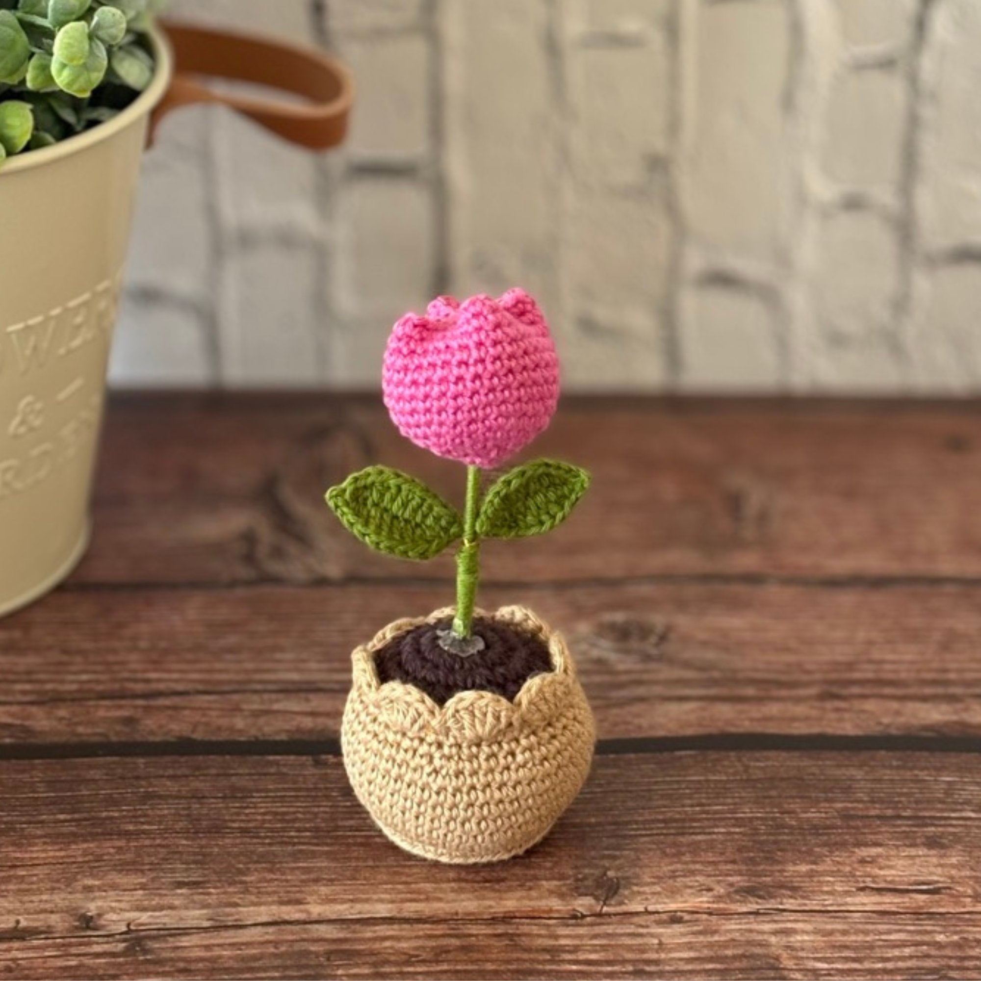 Crochet pink tulip in pot on wooden surface, handmade by Looped Little Things