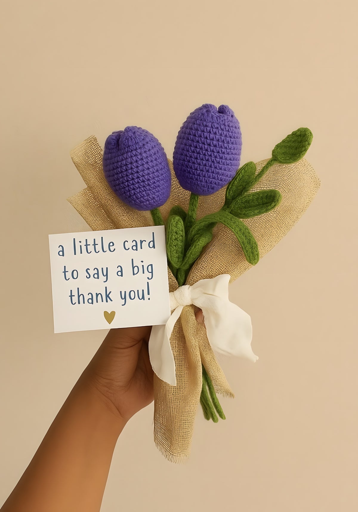 Two purple crochet tulips wrapped in jute with a thank-you card